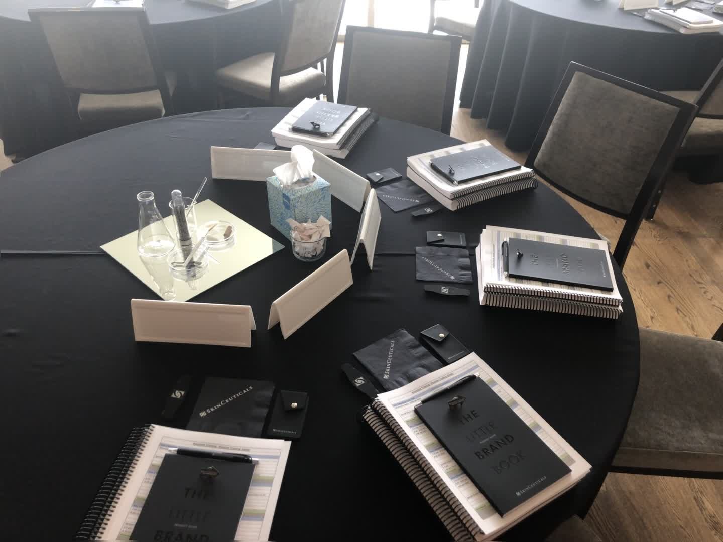 Onboarding materials and brand guides set out for a new-hire aesthetics training session